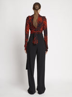 Back full length image of model wearing Painted Spiral Crepe De Chine V-Neck Top in RED MULTI