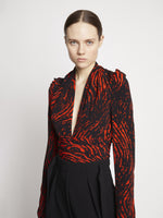 Detail image of model wearing Painted Spiral Crepe De Chine V-Neck Top in RED MULTI