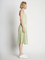 Side full length image of model wearing Drop Waist Faux Leather Dress
 in GREEN TEA