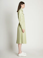 Side full length image of model wearing Faux Leather Pleated Skirt in GREEN TEA
