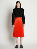 Front full length image of model wearing Faux Leather Pleated Skirt in VERMILLION