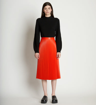 Front full length image of model wearing Faux Leather Pleated Skirt in VERMILLION