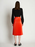 Back full length image of model wearing Faux Leather Pleated Skirt in VERMILLION