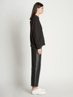 Side full length image of model wearing Long Sleeve Sweatshirt in BLACK