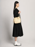 Side image of model carrying Drawstring Pouch in BIRCH