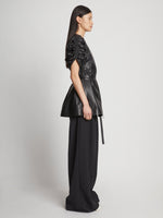 Side full length image of model wearing Leather Belted Top in BLACK