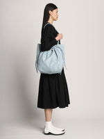 Image of model wearing Drawstring Tote in BLUE STONE