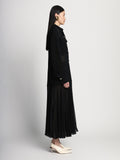Side full length image of model wearing Sheer Pleated Flou Dress in BLACK