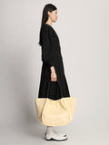 Side image of model wearing  XL Ruched Tote in PALE YELLOW