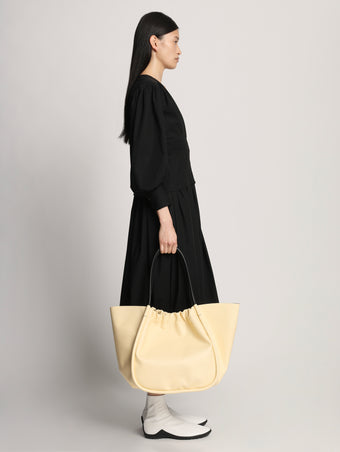 Side image of model wearing  XL Ruched Tote in PALE YELLOW