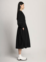 Side full length image of model wearing Poplin V-Neck Dress in BLACK