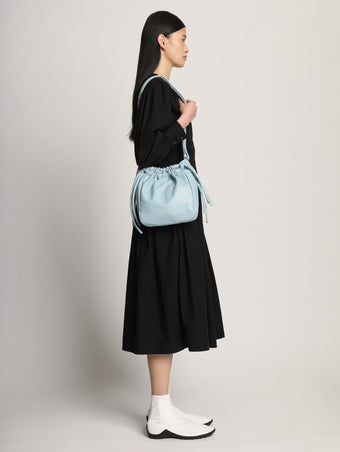 Image of model wearing Drawstring Pouch in BLUE STONE