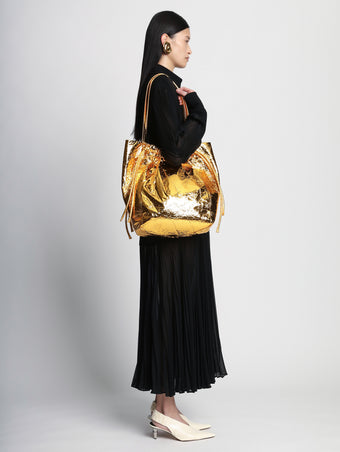 Image of model wearing Metallic Drawstring Tote in GOLD