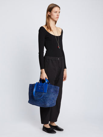 Image of model carrying Large Morris Raffia Tote in COBALT in hand