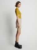 Side image of model wearing Vinyl Mini Skirt in fawn