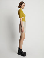 Side image of model wearing Vinyl Mini Skirt in fawn