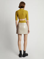 Back image of model wearing Vinyl Mini Skirt in fawn