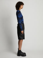 Side image of model wearing Faux Leather Shorts in black