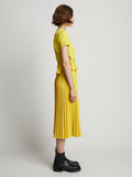Side image of model wearing Faux Leather Pleated Midi Skirt in sun