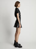 Side image of model wearing Faux Leather Ruffle Mini Dress in black