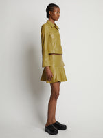Side image of model wearing Leather Ruffle Mini Skirt in sulphur