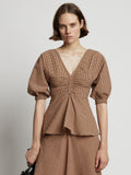 Cropped front image of model wearing Gingham Long Sleeve Peplum Top in coral/black