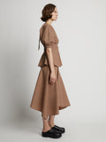 Side image of model wearing Gingham Long Sleeve Peplum Top in coral/black