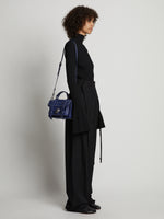 Image of model carrying Topstitch PS1 Tiny Bag in NEW BLUE