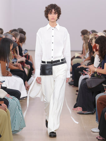 Model Walking Proenza Schouler SS24 Runway In Olympia Dress In White Washed Habotai, Otis Pant In Ivory Viscose Wool Suiting, Zip Belt Bag In Black Calf Leather, Monogram Loafers In Black Nappa