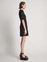 Side image of model wearing Lace Dress in black
