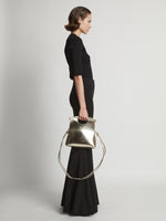 Image of model carrying Small Bar Bag in LIGHT GOLD