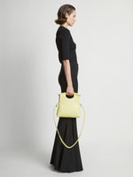 Image of model carrying Small Bar Bag in LEMONGRASS