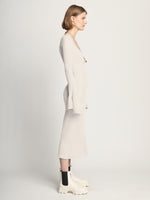 Side image of model wearing Fluted Rib Knit Dress in ivory