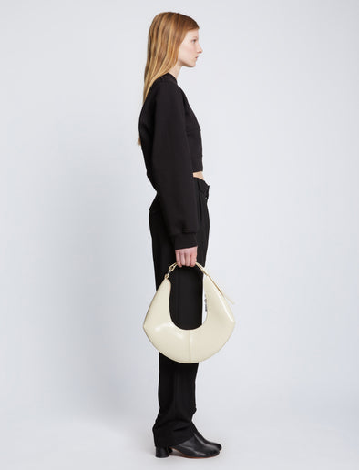 Image of model carrying Chrystie Bag in IVORY in hand