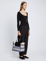 Image of model carrying Large Morris Stripe Canvas Tote in BLACK/WHITE/COBALT in hand