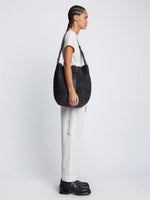 Image of model carrying Sullivan Raffia Bag in BLACK on shoulder