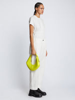 Image of model carrying Small Chrystie Bag in LIME in hand