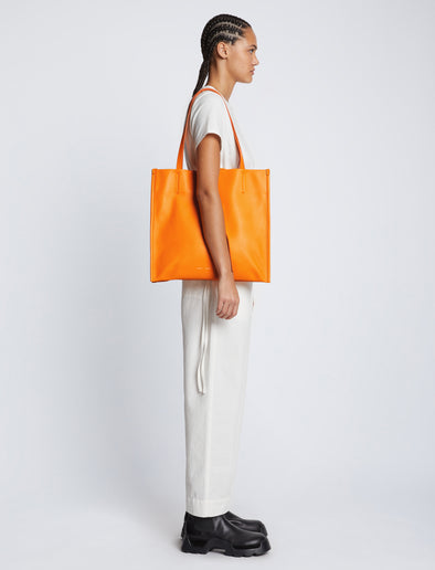 Image of model carrying Twin Nappa Tote in TANGERINE on shoulder