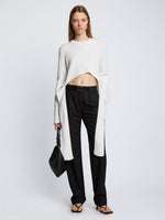 Front full length image of model wearing Ribbed Cotton Wrap Sweater in OFF WHITE with straps hanging by sides