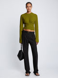 Front full length image of model wearing Ribbed Cotton Wrap Sweater in LEAF with straps tied around waist