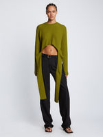 Front full length image of model wearing Ribbed Cotton Wrap Sweater in LEAF with straps hanging by sides