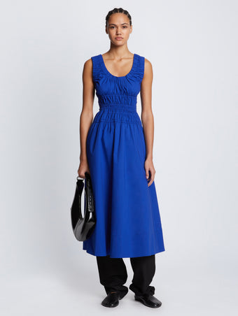Front full length image of model wearing Poplin Gathered Dress in ROYAL BLUE styled over black Viscose Suiting Pants