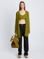 Front full length image of model wearing Ribbed Cotton Relaxed Cardigan in LEAF with belt removed