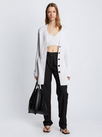 Front full length image of model wearing Ribbed Cotton Relaxed Cardigan in OFF WHITE with belt removed