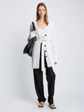 Front full length image of model wearing Ribbed Cotton Relaxed Cardigan in OFF WHITE with belt tied in front
