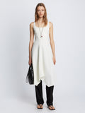 Front full length image of model wearing Barre Bustier Dress in OFF WHITE styled over black Drapey Suiting Pants