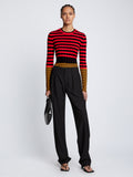 Front full length image of model wearing Slinky Stripe Long Sleeve Sweater in CHERRY/GOLDEN ROD/BLACK tucked in
