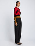 Side full length image of model wearing Slinky Stripe Long Sleeve Sweater in CHERRY/GOLDEN ROD/BLACK