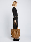 Image of model carrying Drawstring Tote in BARK in hand