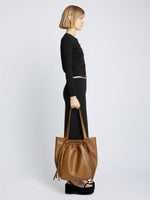Image of model carrying Drawstring Tote in BARK in hand